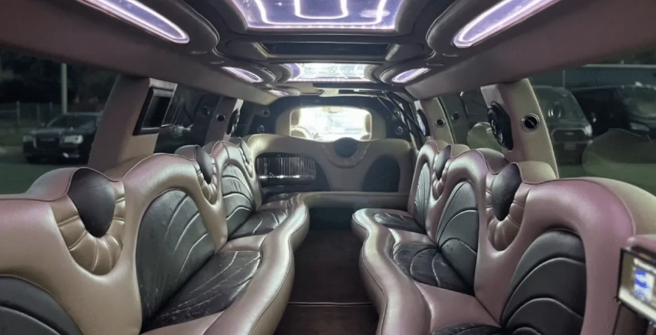 Cadillac Escalade Limousine interior with perimeter lounge seating and LED ceiling lighting for wedding car rental