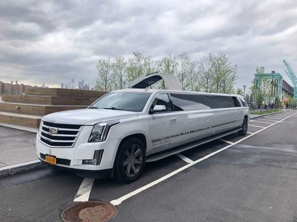 White Cadillac Escalade Limousine with tinted windows for wedding car rental
