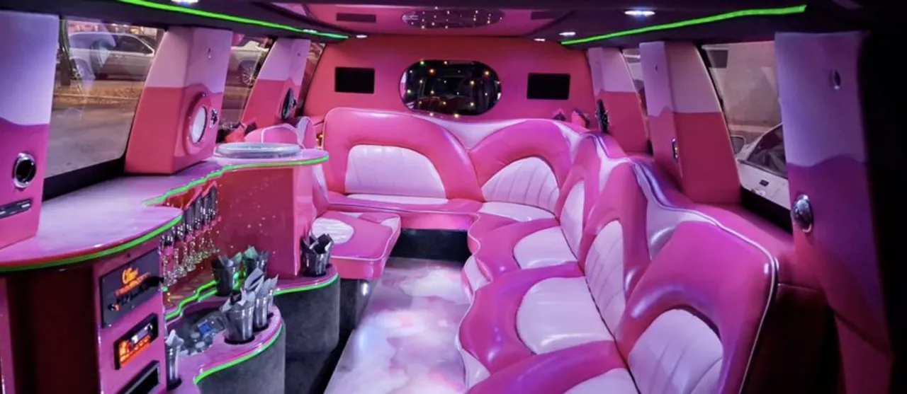 Chevrolet Suburban Limousine interior with sofa-style seating, LED accent lighting and bar area for wedding car rental