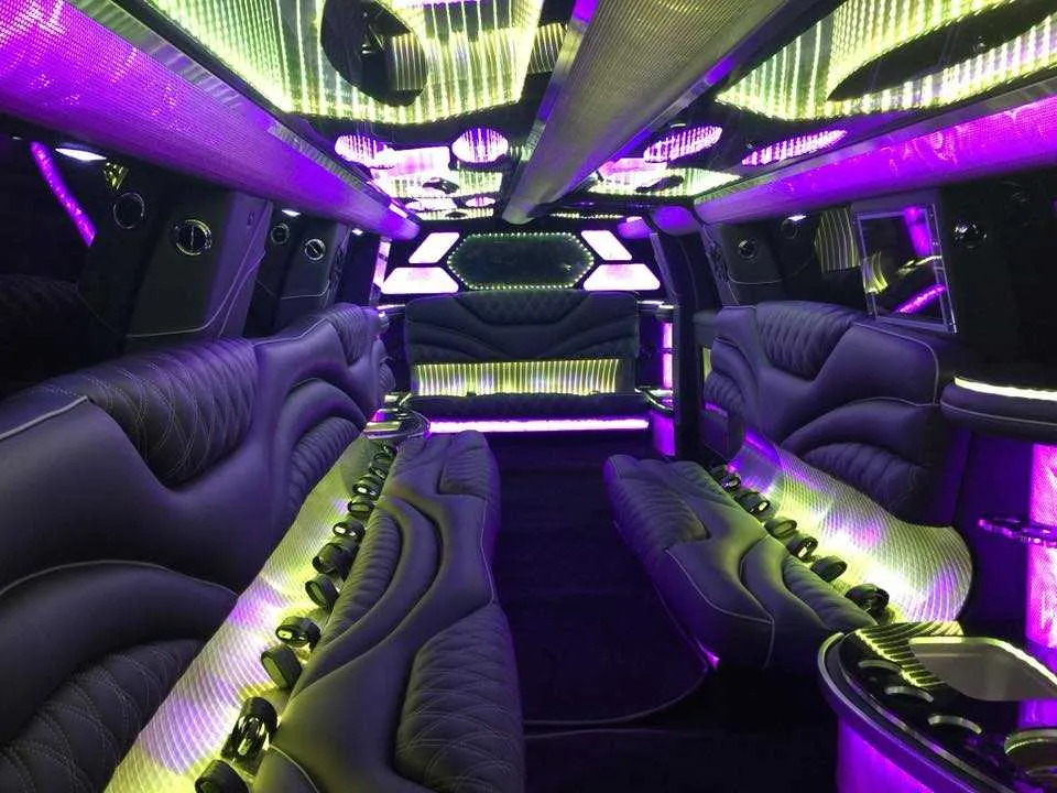 Cadillac Escalade Limousine interior with perimeter lounge seating, LED accent lighting and LED ceiling lighting for wedding car rental
