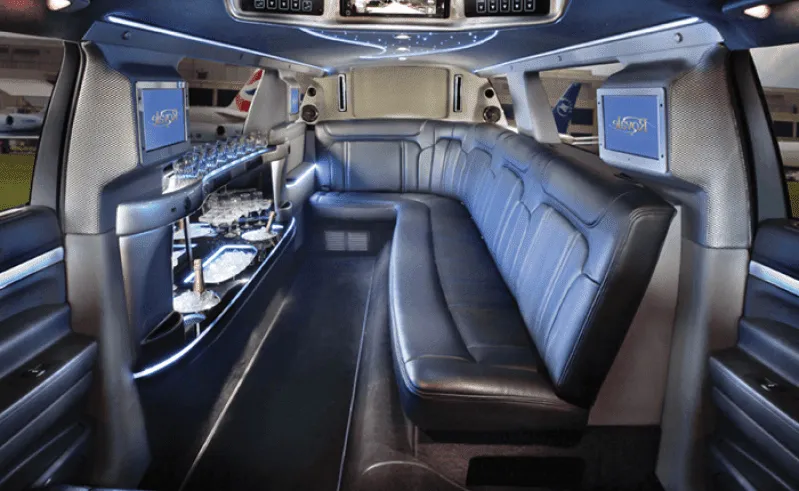 Ford Excursion Limousine Ford Excursion Limousine interior with sofa-style seating, LED accent lighting and bar area for wedding car rental