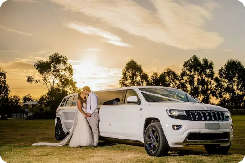 Newlyweds beside a white stretch limousine for wedding limo rental in San Marcos, CA
